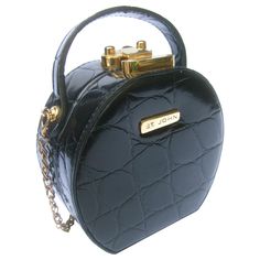 St John embossed vinyl diminutive size handbag - shoulder bag c 1990 The stylish compact size rounded purse is covered with embossed patent black vinyl that emulates reptile skin Designed with a sleek gilt metal latch clasp mechanism. Adorned with a gilt metal plaque inscribed St John on the front exterior. Paired with a detachable gilt metal shoulder strap chain Transitions from a small size handbag; transitions into a stylish compact size shoulder bag carried with the gilt metal chain strap Th Round Purse, Reptile Skin, Structured Shoulder, Couture Vintage, Metal Plaque, Black Vinyl, Luggage Tags, Metal Chain, Black Coat