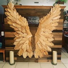 a wooden sculpture with large wings on it