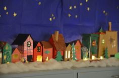 a bunch of houses that are sitting on a shelf in front of a blue wall