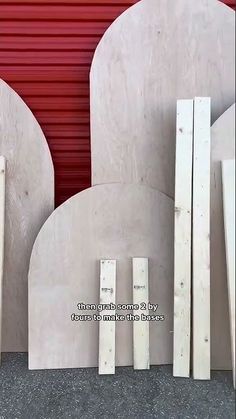 several pieces of wood sitting next to each other in front of a red wall and door