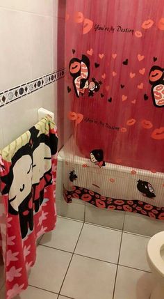 a bathroom with a pink shower curtain next to a toilet