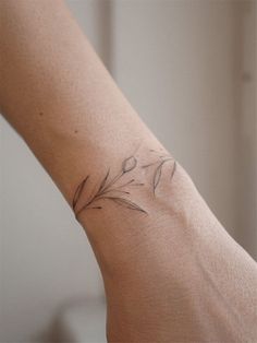 a woman's arm with a small tattoo design on the left side of her arm