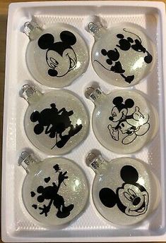 six mickey mouse ornament ornaments in a white tray on top of a wooden table