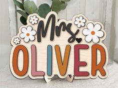 a wooden sign that says mrs and the word's name is written in multicolored letters