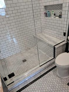 a white toilet sitting next to a walk in shower