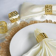 a white plate topped with gold napkins on top of a table