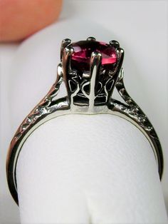 Simulated Red Ruby Ring Wedding #D22 This is a Victorian Era solitaire ring. This lovely sterling silver wedding solitaire has an approximately .5 carat simulated red ruby gemstone. This full cut flawless gemstone is 6mm (1/4") in diameter. The inside of the band is marked 925 for sterling silver. Notice the beautiful crown design of the silver filigree setting and the etched band. This is a lovely rendition of an Antique filigree ring. Classically fashioned, this ring is a vintage wedding style Red Ruby Ring, Antique Filigree, Victorian Wedding, Crown Design, Vintage Style Wedding, Filigree Ring, Ruby Gemstone, Red Ruby, Engraved Items