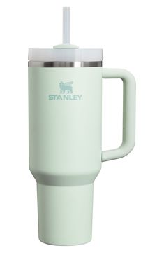 a white travel mug with a straw in the cup and stanley logo on the side