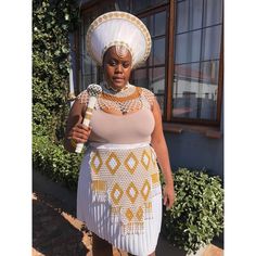 The price is for: 1. A double framed gold and white zulu hat that is embelished with gold and white beads. 2. Beaded stick/knobkerrie 3. White and gold necklace 4. Beaded apron 5. White leather skirt Exquisite White and Gold Zulu Isicholo Hat Set Elevate your cultural attire with our stunning White and Gold Zulu Isicholo Hat Set, a magnificent celebration of South African heritage. This meticulously crafted set includes a traditional isicholo hat, a matching skirt, an elegant necklace, a regal knobkerrie stick, and a beautifully adorned apron. Each piece is designed to honor and preserve the rich traditions of the Zulu people, making it perfect for ceremonial occasions, cultural events, or as a striking display piece. Set Includes: Isicholo Hat: The centerpiece of this set, the isicholo ha Kikuyu Traditional Attire, Zulu Traditional Attire Umemulo, Zulu Maiden Attire, Zulu Traditional Hats For Women, Zulu Hats South Africa, South African Heritage, Isicholo Zulu Hat, Zulu Hat, White Leather Skirt