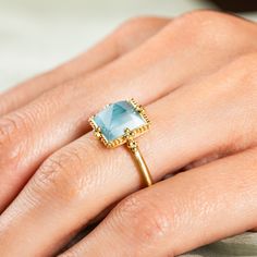 This Aquamarine has a light powder blue hue and striking facets that catch the light. We set this one-of-a-kind gemstone in a handmade gold bezel accented with braided gold and granulated prongs.Ready to ship in size 7. Please allow 1-2 weeks for any other size. Technical Details Metal: 18k yellow goldAquamarine: 3.9 cts. Ring face: 11mm squareBand width: 2mmHandmade in New YorkStyle # R-2670-AQ Handmade Light Blue Aquamarine Jewelry, Fine Jewelry Aquamarine Crystal Ring, Oval Light Blue Aquamarine Jewelry, Rectangular Aquamarine Blue Jewelry, Elegant Hand-strung Aquamarine Jewelry, Mixed Metal Bracelets, Textile Necklace, Aquamarine Ring, Aquamarine Rings