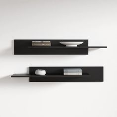 two black shelves with books and bowls on them