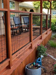 a wooden deck with metal railings and chairs