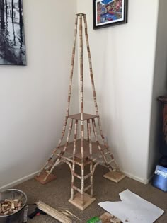 a wooden tower sitting on top of a carpeted floor next to a framed picture