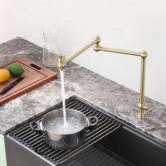 a kitchen sink with a strainer that has water running from the faucet