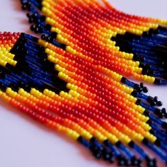 two pieces of beaded art on a white surface