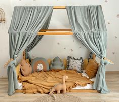 a child's bed with curtains and toys on the floor