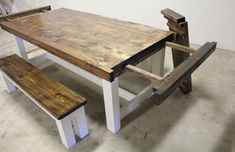 a table and bench made out of wood with two benches next to it on the floor