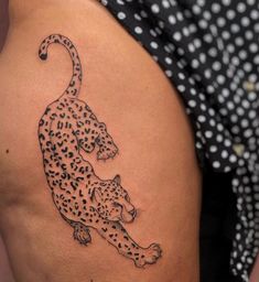 a black and white tattoo of a leopard on the back of a woman's thigh