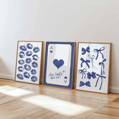 three framed art pieces sitting on top of a hard wood floor