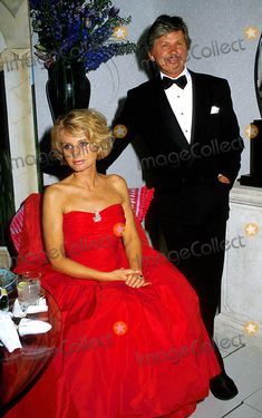 a man in a tuxedo standing next to a woman in a red dress