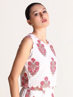 Featuring a scallop embroidery detailing, this one-of-a-kind motif print top is a piece of art that can’t be duplicated. Meticulously crafted from cotton and lined with mulmul, this top feels like second skin — incredibly soft and breathable! You won’t be able to resist falling head over heels for this gorgeous sleeveless top, which is the epitome of elegance. Rock it with the Magnolia Motif Print Skirt & with some chunky jewellery and sassy footwear while the print celebrates the real you! Mate Fitted Tops With Printed Motifs For Summer, Floral Print Summer Festive Tops, Festive Floral Print Summer Tops, Festive Summer Floral Print Tops, Fitted Bohemian Top With Printed Motifs, Fitted Tops With Printed Motifs, Cotton Tops With Scalloped Edges For Spring, Spring Cotton Tops With Printed Motifs, Bohemian Cotton Tops With Printed Motifs