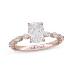 a rose gold engagement ring with an oval cut diamond in the center and side stones