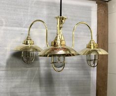 three brass colored lights hanging from the ceiling