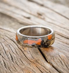 an orange and black ring sitting on top of a wooden table