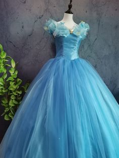 a blue ball gown on display in front of a wall