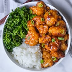 a white bowl filled with rice and meat next to broccoli on top of a table