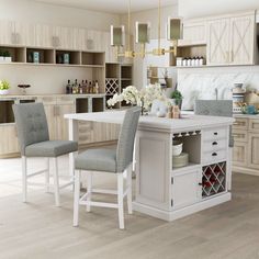 a kitchen with white cabinets and gray chairs