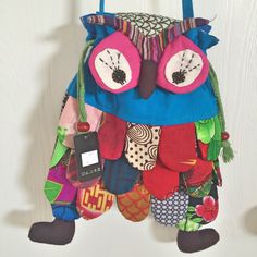 an owl hanging from the side of a wall with lots of different items on it