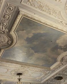 an ornate ceiling painted with clouds and birds