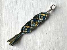 a beaded keychain with a tassel hanging from it's side