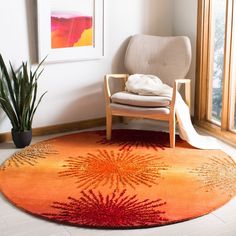 a living room area with a chair, rug and potted plant