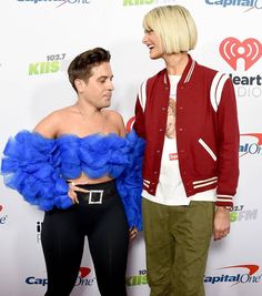 two people standing next to each other on a red carpet