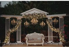 an outdoor seating area with flowers and chandelier