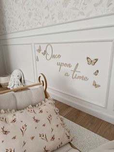 there is a baby crib in the room with butterflies on the wall and a stuffed animal