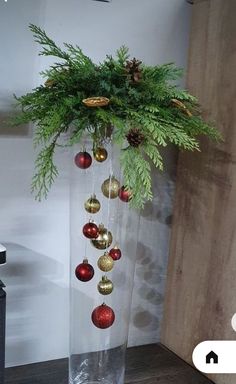 a vase filled with christmas ornaments on top of a wooden table next to a wall