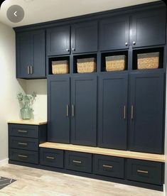 an empty room with blue cabinets and baskets on the wall, in front of a window