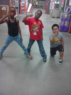 three children are standing in the middle of a store