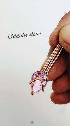 a person holding a pink stone in their left hand with the words aid the store above it