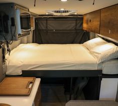 a bed in the back of a truck with a tv on it's side