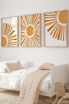 a white bed sitting next to two paintings on the wall in a bedroom with beige and white decor