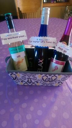 several bottles of wine sitting in a basket on top of a purple tablecloth covered table