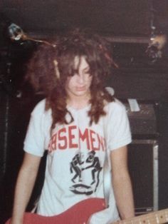 a young man with long hair playing an electric guitar in front of a keyboard and amp