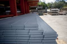 several stacks of gray concrete sitting on top of a pallet in front of a building