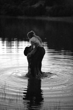 two people are in the water and one is holding onto another person's back