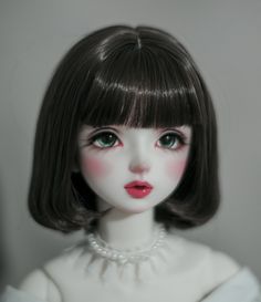 a close up of a doll wearing a necklace