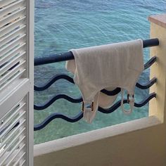 a towel is hanging on a rail next to the ocean